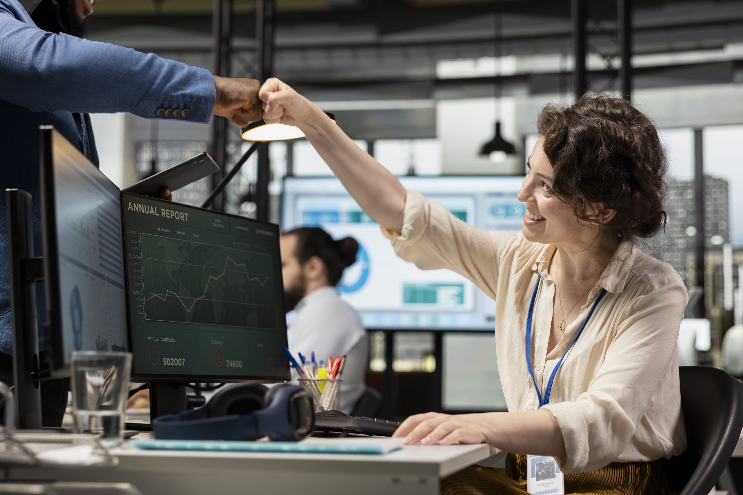 multiethnic colleagues greeting each other with fist bump in corporate space